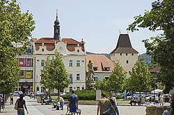 Husovo náměstí s radnicí, v pozadí městská brána